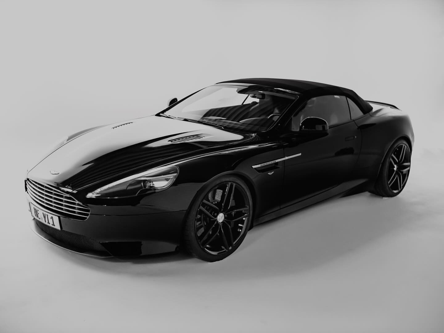 Schwarzer Aston Martin DB9 vor der weißen Hohlkehle