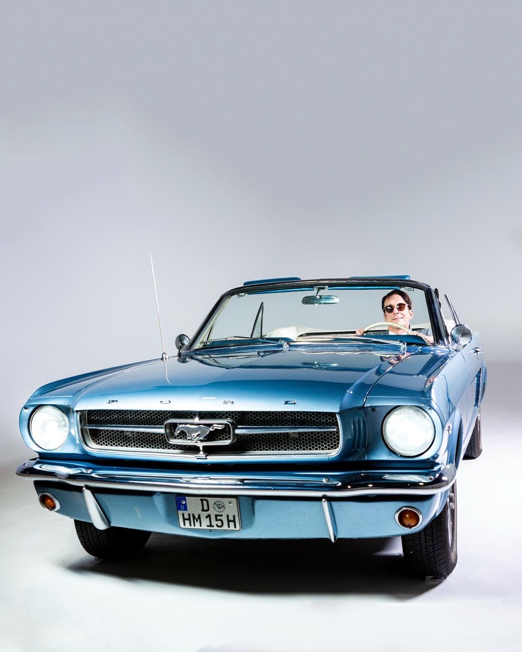 Blauer Ford Mustang Cabrio von vorn in der Hohlkehle