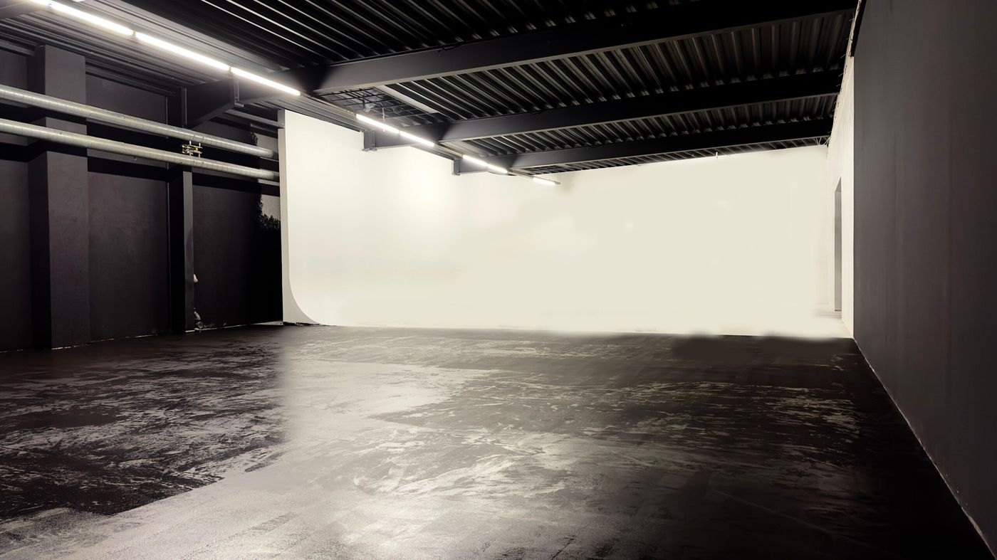 Die leere Halle: dunkler Boden, weiße Hohlkehle, Traverse unter der Decke