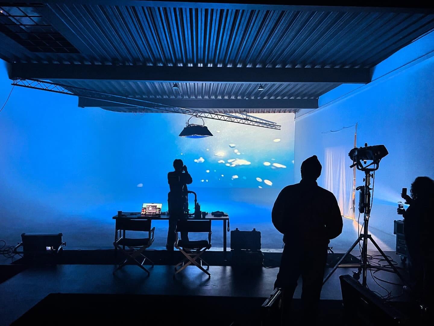 Videodreh vor einer blau leuchtenden Wasser-Projektion