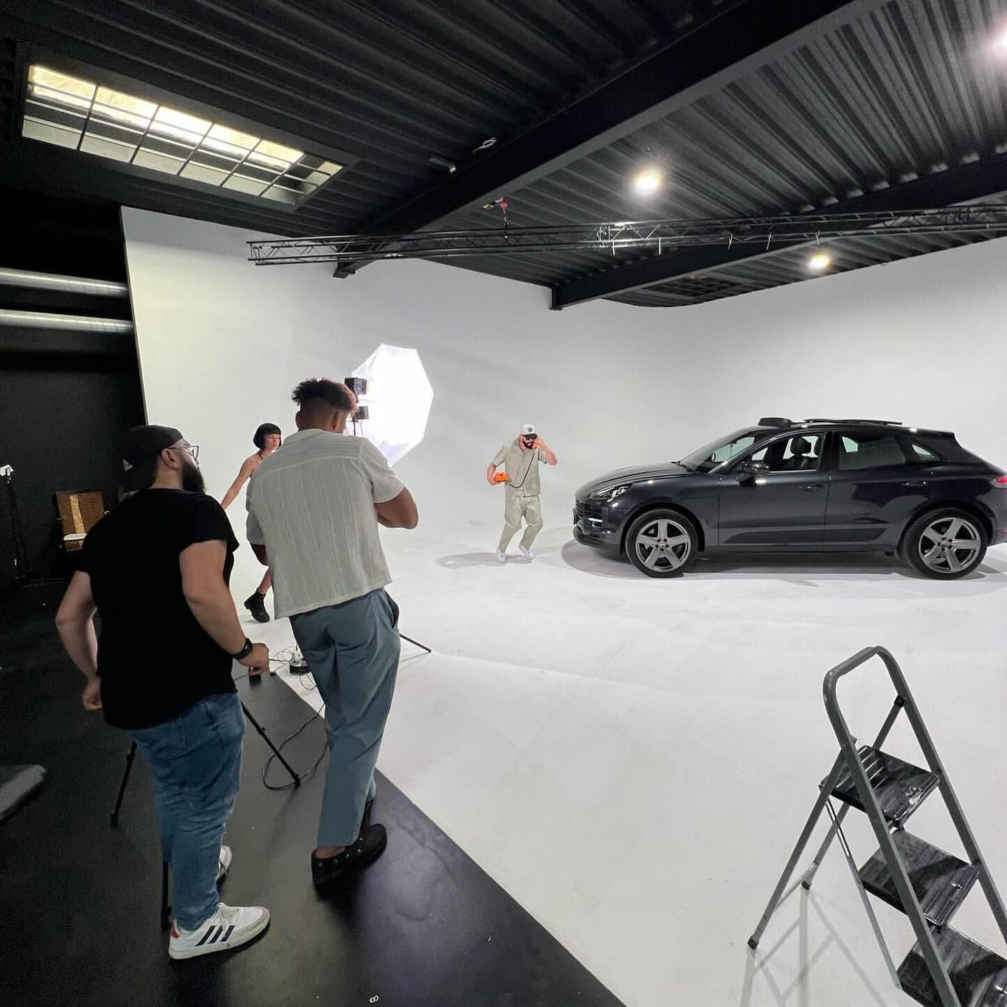 Musikvideo-Dreh: Crew und Artists vor einem Porsche Macan in der Hohlkehle