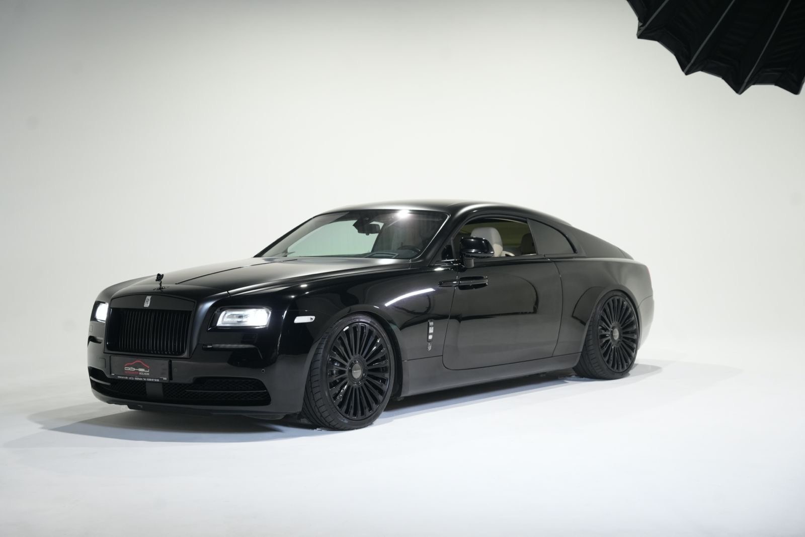 Schwarzer Rolls-Royce Wraith in der weißen Hohlkehle